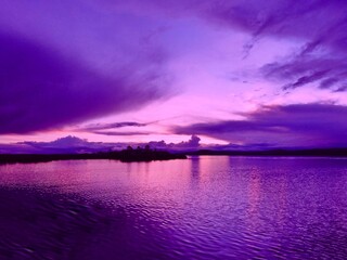 Wall Mural - Purple sunset over the lake Titicaca at night. Magical dusk over calm glittering water.