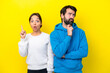 © luismolinero - Young caucasian couple isolated on yellow background standing and thinking an idea
