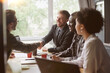 © yurolaitsalbert - business people greet each other at the table in the coworking c
