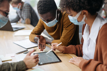 Wall Mural - employees in protective masks using a digital tablet.