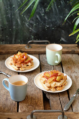 Sticker - Waffles with caramel apples. Wooden background. Side view. 