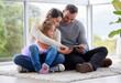 © Nina L/peopleimages.com - Happiness personified. Shot of a young family using a digital tablet at home.
