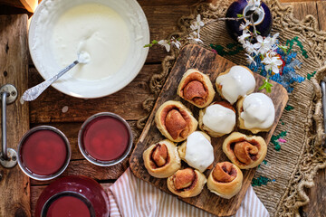 Sticker - Buns with cinnamon and cream sauce. cherry compote. top view.