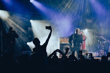 Canvas Print - Silhouette of a woman using smartphone on a concert