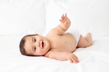 Happy Baby Boy Lying On The Side On White Bed