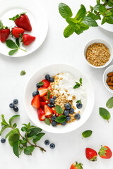 Poster - Breakfast bowl with granola, plain yogurt, strawberry and blueberry, top view