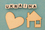 Fototapeta  - Napis Ukraina leżący nad drewnianym sercem i domem - symobliczne znaczenie