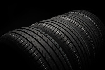  New car tires. Group of road wheels on dark background. Summer Tires with asymmetric tread design. Driving car concept.
