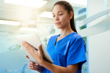 Aufkleber - Time for a second opinion. Shot of a young nurse using a tablet while standing inside a clinic.