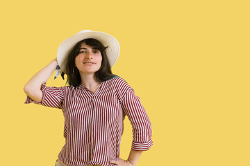 beautiful attractive stylish brunette woman posing isolated on yellow studio background in trendy fashion clothes outfit and hat