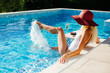 © shevtsovy - happy woman relax in swimming pool on summer vacations. Sexy woman in swimsuit splashing water drops and having fun. Summer vacation time.