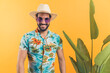 good-looking Hispanic man in casual summer clothes standing next to green leaves and enjoying with summer vacation concept medium shot studio shot orange background. High quality photo