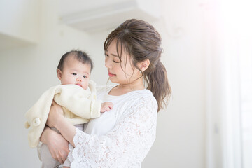 a mother holding and nursing her baby in a brightly lit living room
