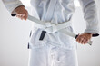 Ready to get started. Cropped shot of an unrecognizable male martial artist tying his belt in the gym.