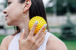 close - up portrait in profile of young woman face blured with spiky massage ball for myofascial release and pain relief in neck and shoulders. 