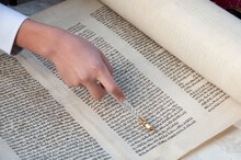 Reading The Torah, The Five Holy Books Of Moses And Judaism With The Assistance Of A Pointer Or Yad To Guide The Reader Through The Hebrew Text.
