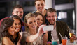 © Koegelenberg/peopleimages.com - We dont need an excuse for a selfie. Shot of a happy group of friends taking a selfie while having drinks at a bar together.