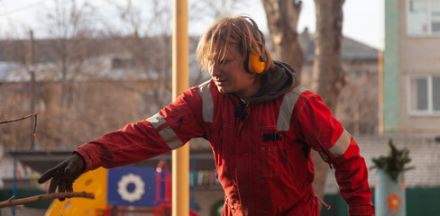 Wall Mural - Tree surgeon. Working with a chainsaw. Sawing wood with a chainsaw.