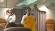 © sorapop - Asian stewardess safety explaining passengers prior to flight take off in airplane, air hostess uniform safety demonstration presenting pre-flight safety instructions life vest in emergency situation