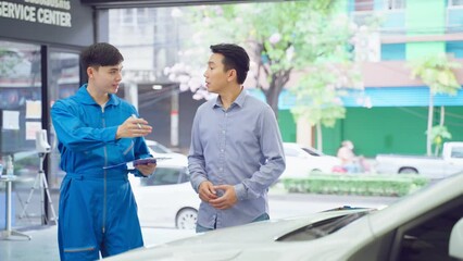 Wall Mural - Asian automotive mechanic explain car condition to client in garage. 