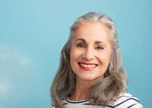 Smiling Woman With Gray Hair On Blue Background