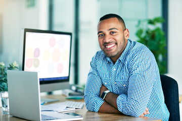 Wall Mural - I always meet my deadline. Portrait of a handsome young businessman working on his laptop in the office.