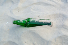 A Green Glass Bottle On The Sand