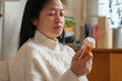 © weedezign - asian woman reading pill prescription when get flu on soaf at home