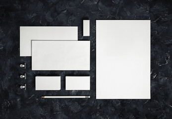 Wall Mural - Photo of blank stationery set on black plaster background. Corporate identity template. Responsive design mockup. Top view.