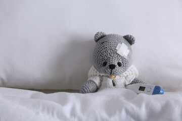 Wall Mural - Cute toy bear with sticking plaster and thermometer in bed. Children's hospital