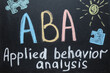 Text ABA Applied behavior analysis and drawings on blackboard