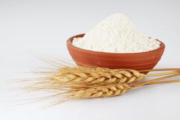 Wall Mural - Wheat flour Bunch of wheat ears, dried grains in terracotta bowl, flour in terracotta bowl on white background. Cereals harvesting, bakery products