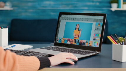 Photography student editing picture on retouching software, working on laptop for online design production class. Retoucher using color grading to edit photograph on computer, remote work. Close up.