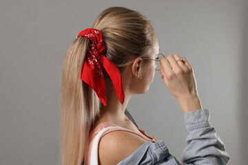 Woman with stylish red bandana on light grey background