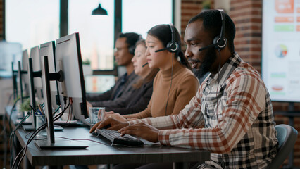 african american man working at call center office to help people with telemarketing assistance. mal