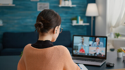 Wall Mural - Female student talking on online class video call to study from home, attending teleconference meeting on webcam. Young woman learning knowledge on videoconference call discussion.