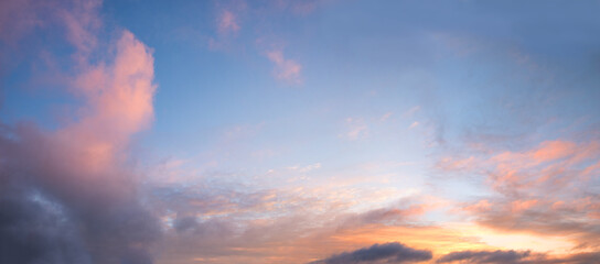 Wall Mural - blue sky background, framed with pink yellow and orange clouds, sunset scenery