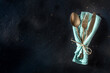 Cutlery. A spoon, a fork, and a knife in a teal napkin on a black slate background. Modern silverware on a dark table with copy space, overhead flat lay shot