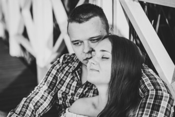 Wall Mural - Couple hugging and kissing at sunset on pier. Black and white photo.