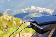 Powerbank Charges The Phone On The Background Of The Mountains