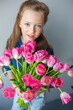 © Andreshkova Nastya - Happy adorable girl with pink fresh bouquet of tulips. Childhood,  flowers concept