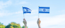 Hand Holding Israel Flag On Nature Background. Israel Independence Day And Happy Celebration Concepts
