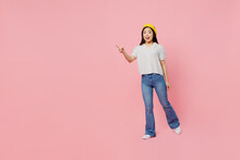 Full Body Young Woman Of Asian Ethnicity 20s Wear White Polka Dot T-shirt Yellow Beret Point Index Finger Aside On Workspace Area Isolated On Plain Pastel Pink Background. People Lifestyle Concept