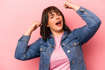 Young caucasian woman isolated on pink background raising fist after a victory, winner concept.