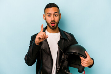 Wall Mural - Young hispanic biker man isolated on blue background having an idea, inspiration concept.