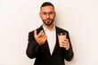 © Asier - Young business hispanic man holding takeaway coffee isolated on white background pointing with finger at you as if inviting come closer.