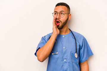 Wall Mural - Young hispanic nurse man isolated on white background is saying a secret hot braking news and looking aside