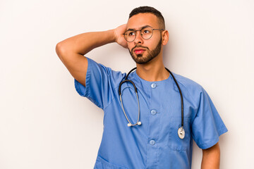 Wall Mural - Young hispanic nurse man isolated on white background touching back of head, thinking and making a choice.