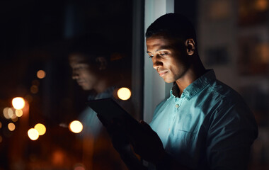 Its time you also get connected. Shot of a handsome young businessman using a digital tablet while working late in his office.