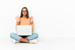 © luismolinero - Young woman with a laptop sitting on the floor in zen pose